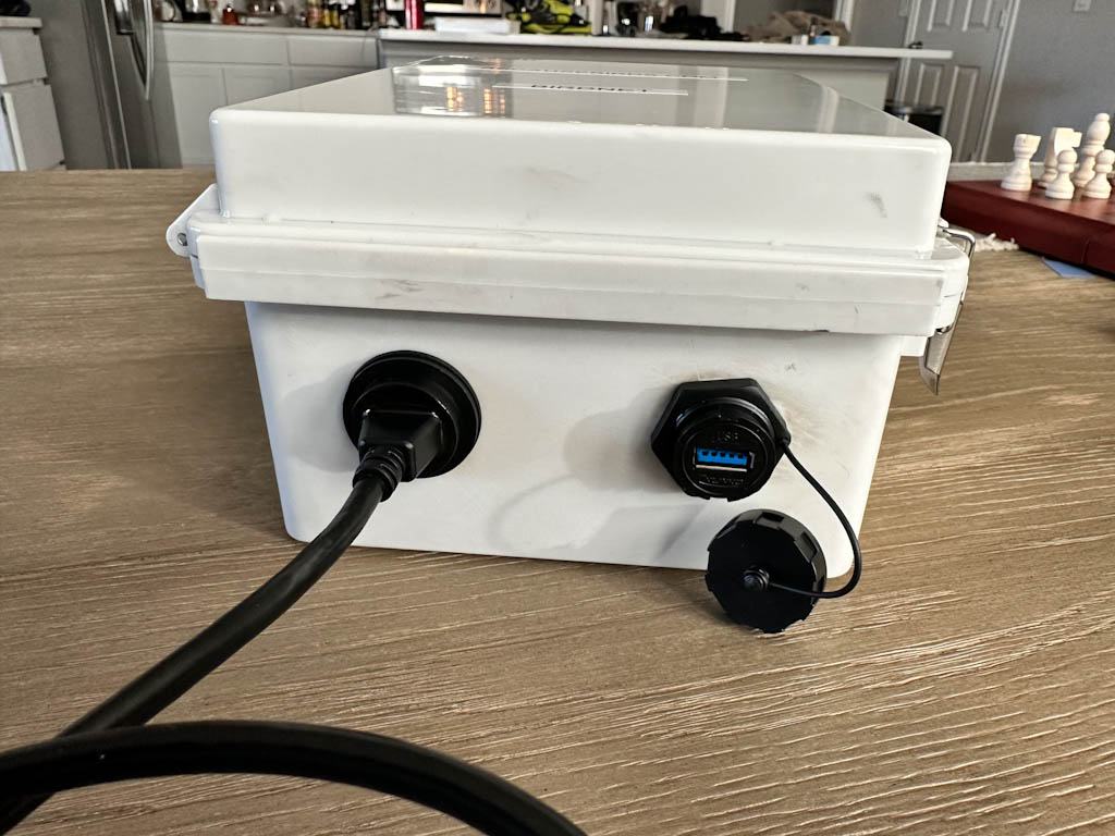 The bottom side of the enclosure. It offers a USB port on the outside on the right and a USB port inside on the left. The idea to flip the left cable the other way ended up being both necessary and beneficial for my setup.