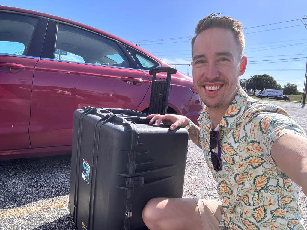 jeff and the pelican case next to a car